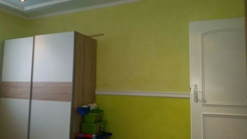 Gelbe Wand und ein Kleiderschrank